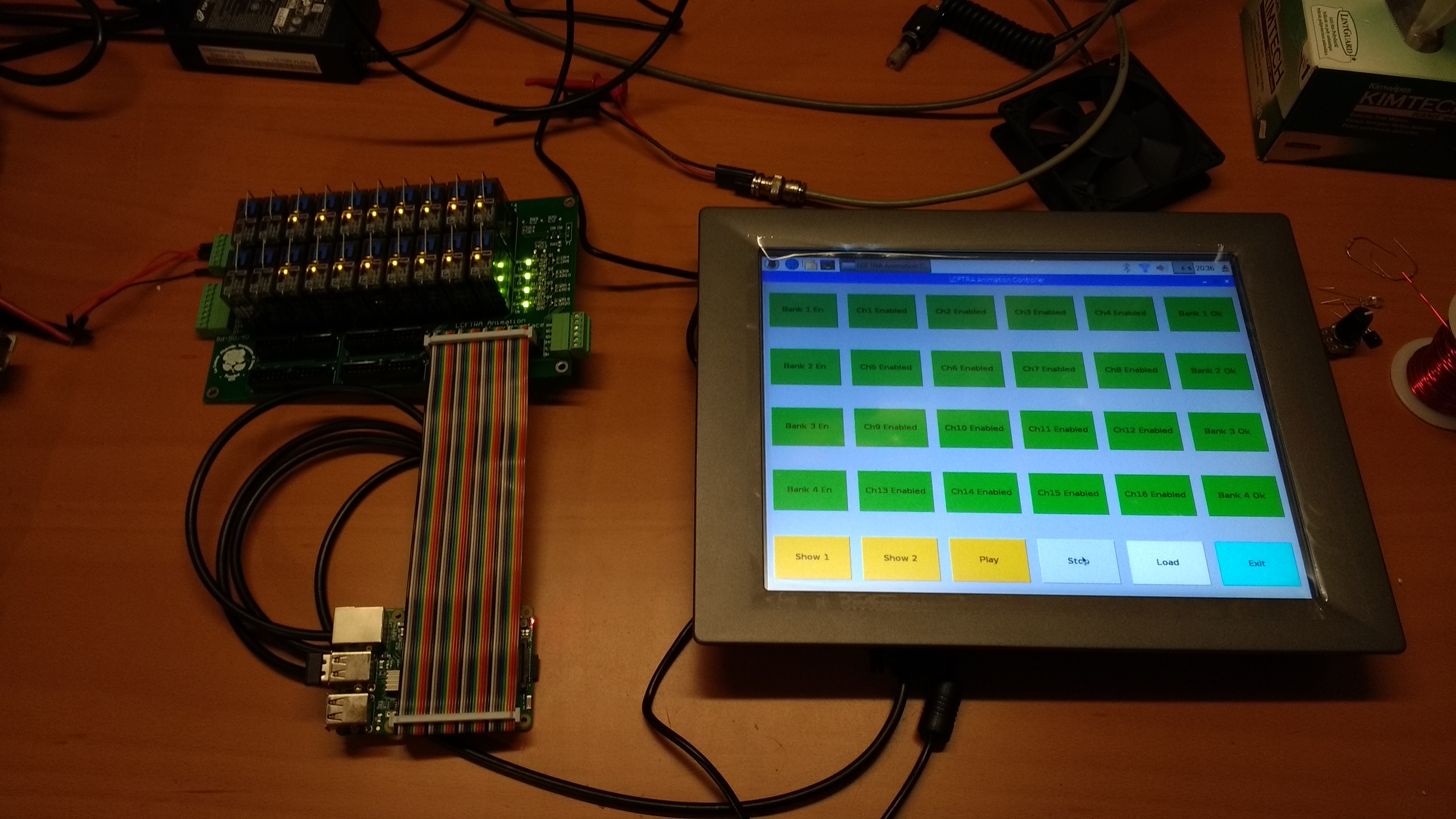 The touchscreen sitting on a lab bench next to the controller interface PCBA and raspberry pi